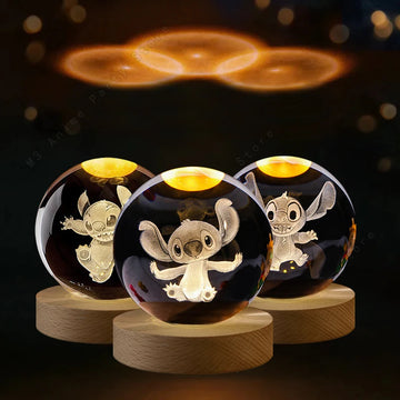 Three crystal balls with engraved cartoon characters on wooden bases against a dark background.